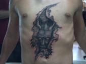 Demon tearing out of chest - chest tattoo